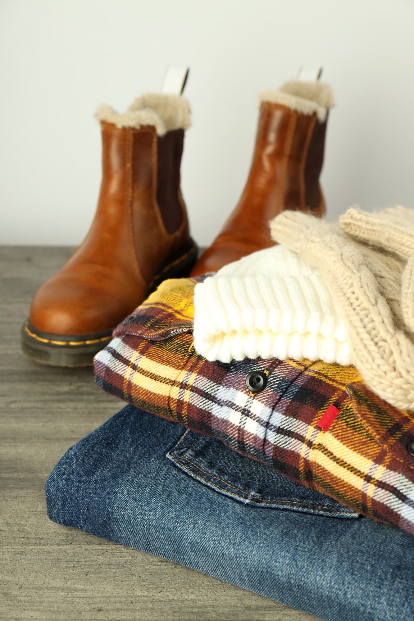 Concept of winter clothes on gray wooden table